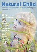 Natural Child Magazine cover with a young woman looking up standing in a golden grain field